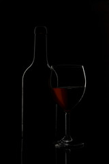 bicchiere di vino con bottiglia sullo sfondo