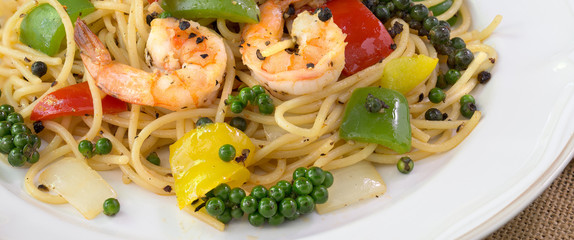 Spaghetti Prawns Stir Black pepper sauce Delicious Thai food in white dish on dark background.