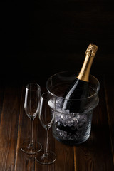 Photo of two glasses, bucket of ice and bottle of wine