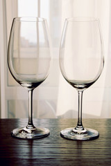 Two empty wine glasses on wooden table close up