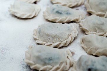 Vareniki (dumplings) with potatoes on white background - traditional Ukrainian and Russian food. Cooking raw dumplings with potatoes. Ravioli