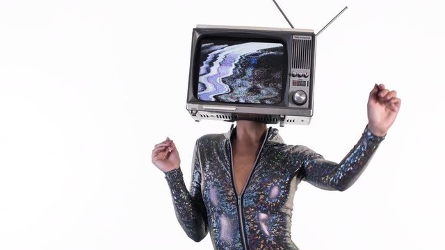 amazing woman dancing and posing with a television as a head. the tv is has video static and noise playing on it.