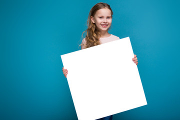 Pretty, little girl in sweater with brunet hair hold clean paper