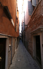 narrow street called CALLE in Italian Language  between tall hou