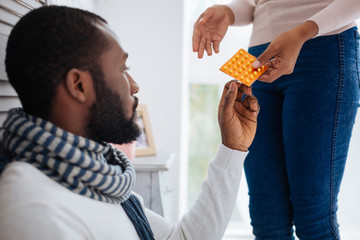 Caring loving girlfriend giving a package of pills