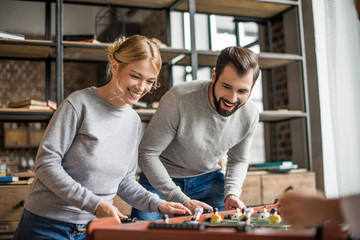 couple playing table football at home