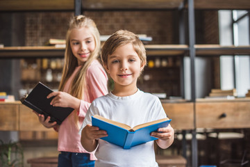 smiling siblings with books