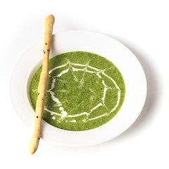 Bowl of broccoli and green peas cream soup with breadstick isolated on white background. Vegetarian cuisine