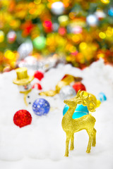 Deer and Christmas decoration in snow on glittery background