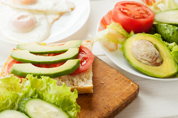Sliced avocado, tomatoes, cucumber on a fresh ciabatta bread