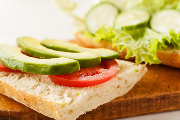 Sliced avocado, tomatoes, cucumber on a fresh ciabatta bread