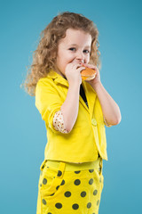 Cute young girl dressed all in yellow with burger