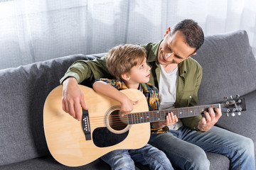 father and son playing guitar together