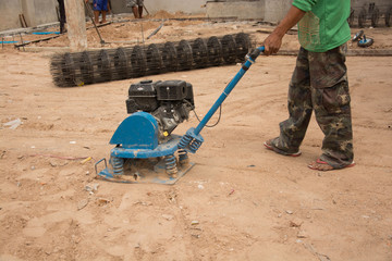The technician is using a soil compactor.