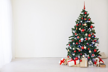 Christmas tree with red gifts in the white room Christmas