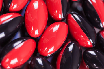 a scattering of red-black brown pills on the mirror background