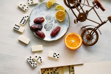 Fun atmosphere of a cozy evening eating dates, oranges, dominoes and dreams about travel