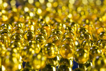 yellow medical capsules on a mirror surface