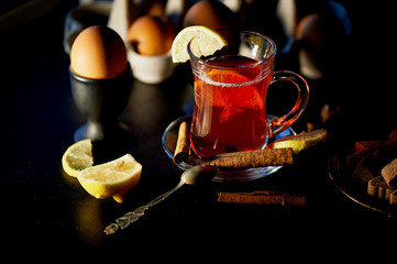 The atmosphere of new year atmosphere. Kettle on stand with warming candles. In a kettle of mulled...