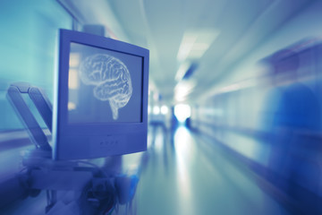 Monitor with brain image and blurred silhouette of doctor in the hospital hallway as a concept of psychiatry