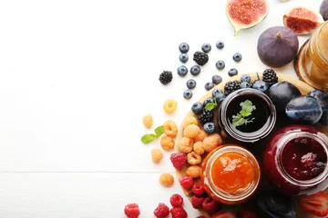 Foto op Plexiglas Glass jars with different kinds of jam and berries on wooden table © 5second