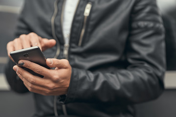 Close-up. The guy is holding a smartphone in his hands. Prints on the smartphone. On the street