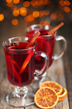 Mulled wine in glasses with spices on wooden table