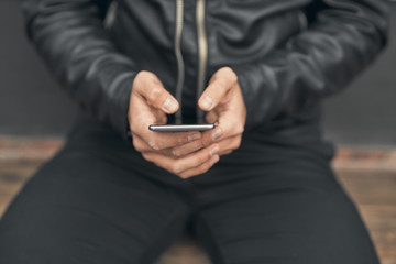 Close-up. The guy is holding a smartphone in his hands. Prints on the smartphone. On the street
