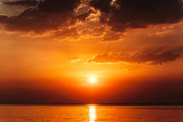 Beautiful and dramatic red and orange marine sunset with clouds. Nobody, clear sea, perfect nature background.
