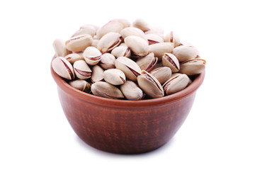 Heap of pistachios in bowl isolated on white
