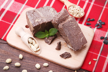 Tasty pieces of halva with mint leaf on cutting board