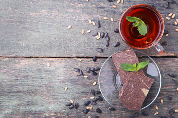 Tasty halva with cocoa and cup of tea on wooden table