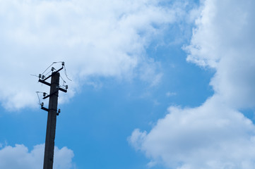 Old pillar and broken power line in sky background