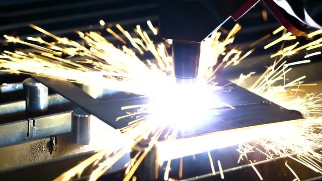 An automated torch cutting a steel plate
