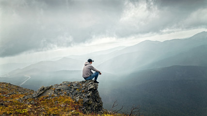 Man sitting on a mountain and thinks