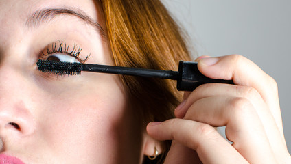 Obraz premium A woman painting her lashes.