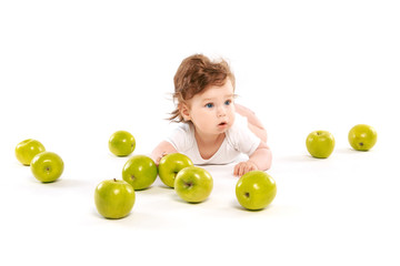 Fototapeta na wymiar funny baby surrounded by green apples