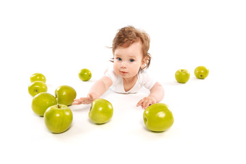 Fototapeta na wymiar little boy on the floor with green apples