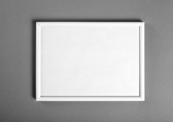 White wooden frame for painting or picture on grey background.