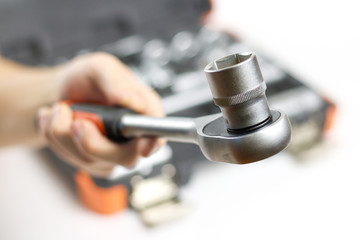 Obraz premium The hand holding the tool. Tool kit for the car. Isolated on white background
