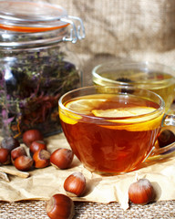  Breakfast with a cup of black and herbal hot tea with hazelnuts on a beige background