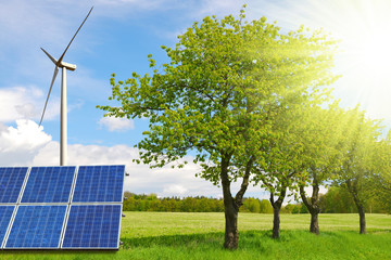 Solar panels with wind turbine on the meadow. Power plant generate clean energy. Environmental...