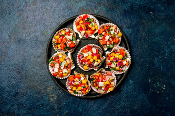 Peruvian style food Scallops a la chalaca. Scallops with onion, tomato, maize, cilantro and lemon