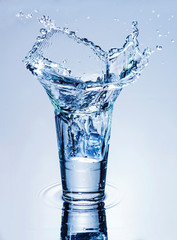 Fototapeta na wymiar icecube splashing into a glass of water