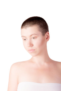 Portrait of sad woman with bald haircut with bare shoulders on isolated white background
