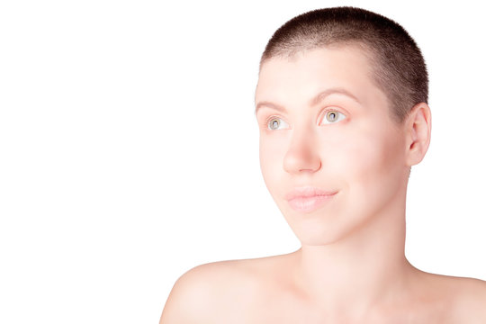 Portrait of positive woman with bald haircut with bare shoulders on isolated white background