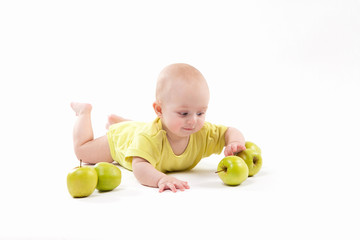 Fototapeta premium smiling baby lying on the background to include apples