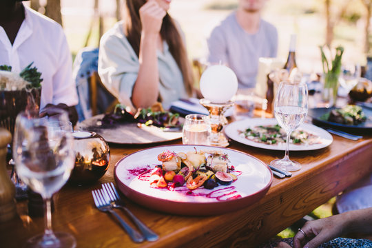 Grouo Of People Enjoying Food And Wine At Restaurant