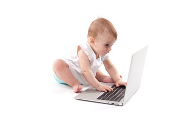 curious smiling child sitting near the laptop on a white background