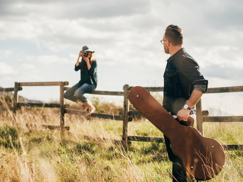 Woman taking shot of man with guitar